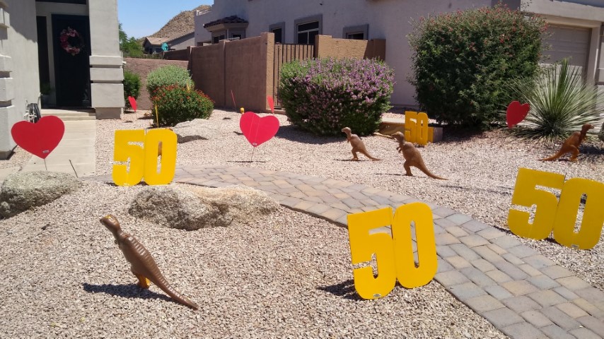 Dinosaurs, heart and big number 50s in birthday yard card near Scottsdale