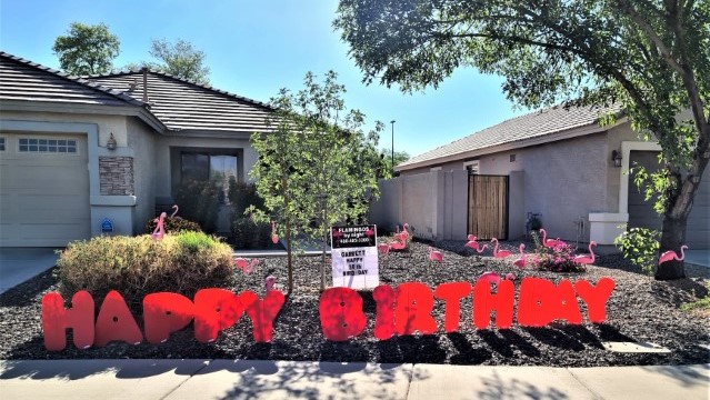 orange Happy Birthday yard sign greeting with flock of flamingos in Avondale AZ