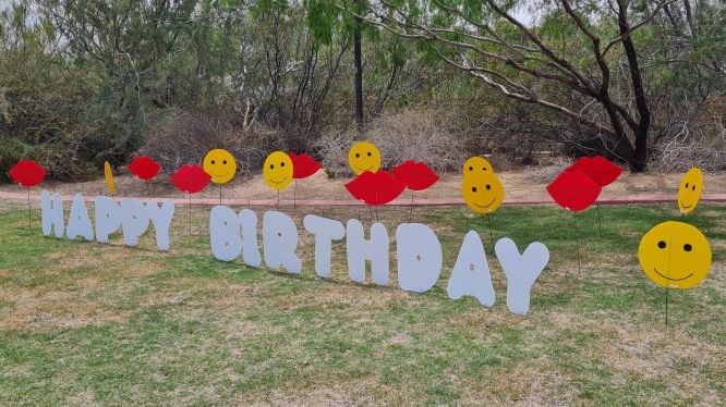 big white Happy Birthday letters smileys and kisses in yard