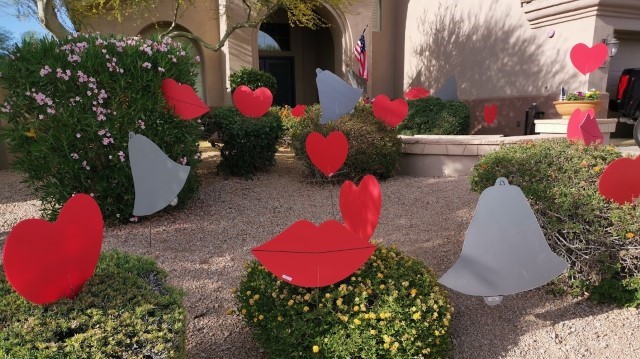 Bells, big number 20s, red hearts and kisses happy anniversary surprise in yard near Anthem