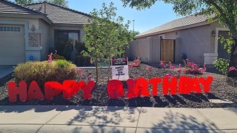 big red Happy Birthday letters and flamingos in yard bor birthday. Near Chandler AZ